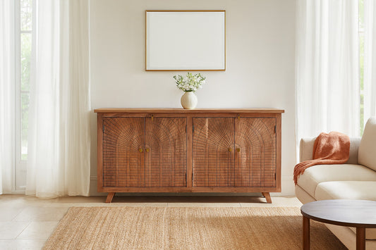 Wooden sideboard in a living room with a vase and framed picture on a white wall.