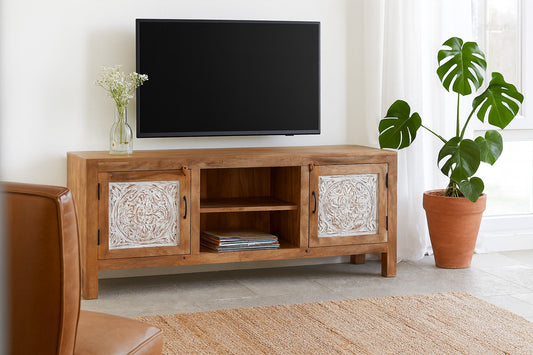 Wooden TV stand with decorative elements in a living room setting.