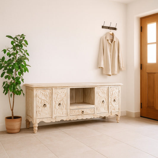 Decorative wooden sideboard in a room with a plant and a door.