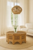 Wicker coffee table with a vase of flowers in a living room setting