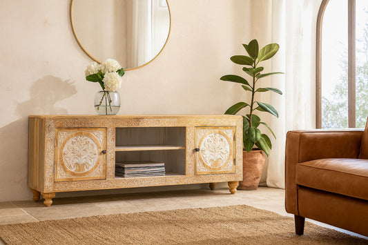 Wooden TV stand with decorative elements in a living room setting.