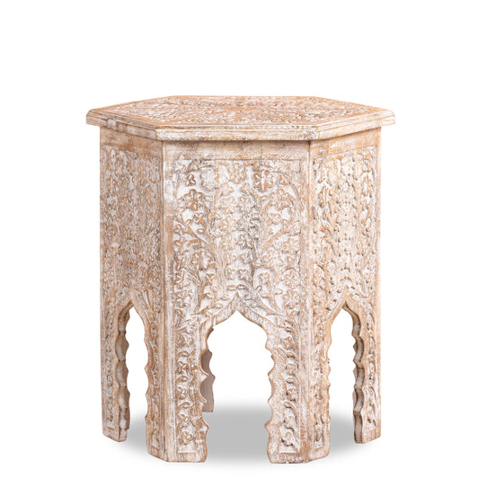 Carved wooden side table with intricate patterns on a white background