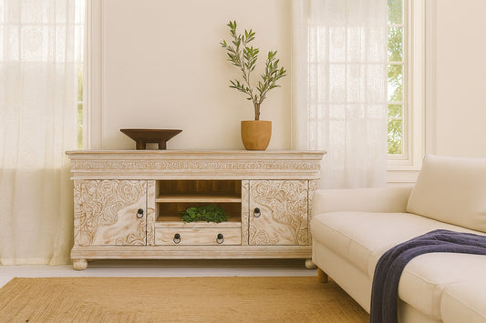 Decorative TV stand with ornate carvings in a living room setting.