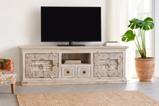 TV on a wooden stand in a living room with a plant and chair.